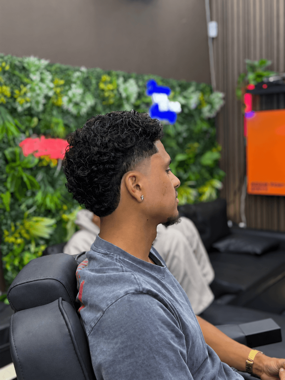 Zijprofiel van krullend haar met een taper fade in mullet-vorm