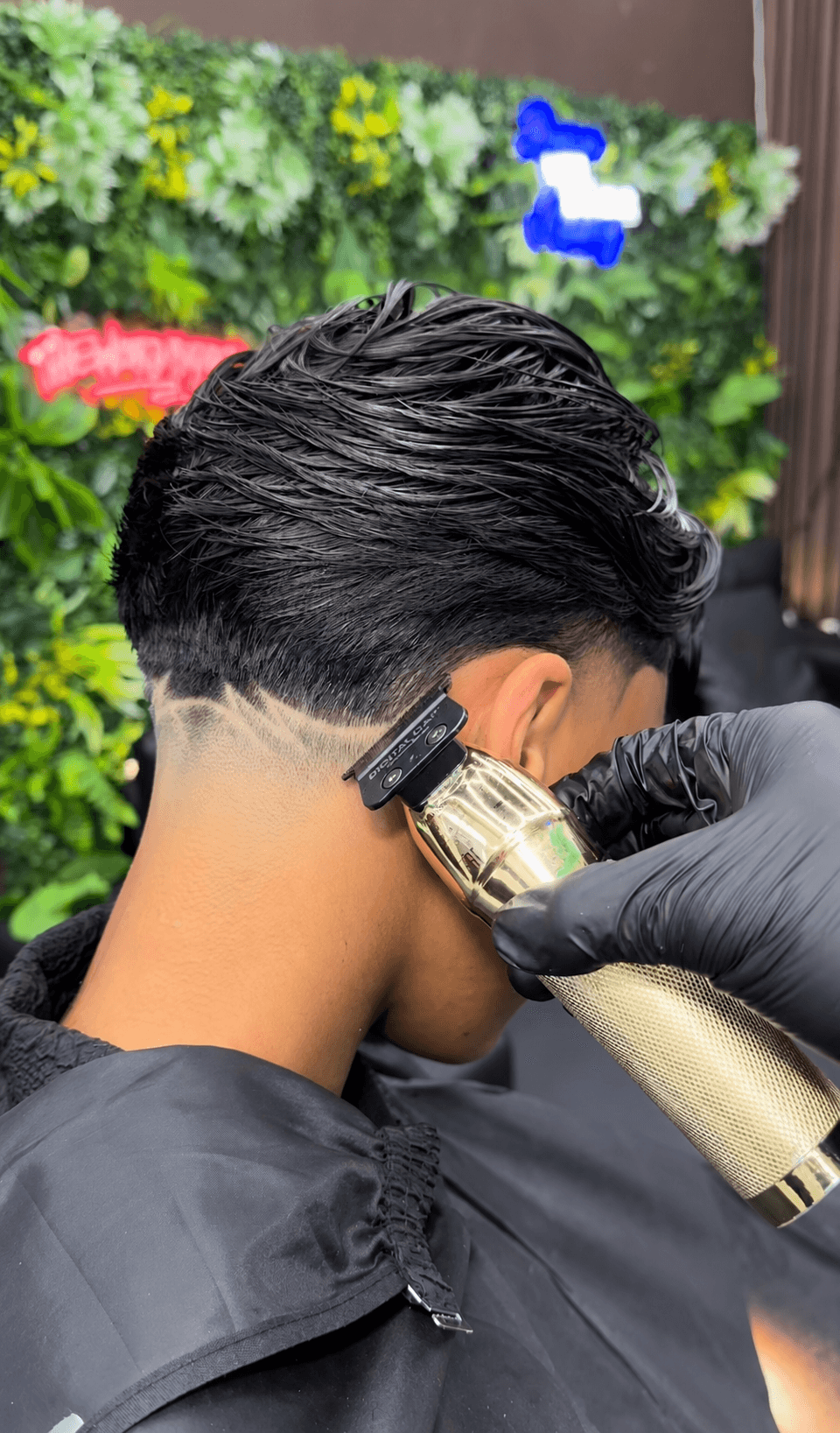 Close-up van een fade met freestyle lijnen in de nek, bijgewerkt met een trimmer